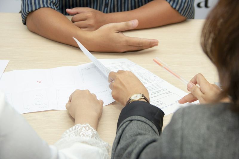 Mãos sobre um contrato durante uma conversa de negócios